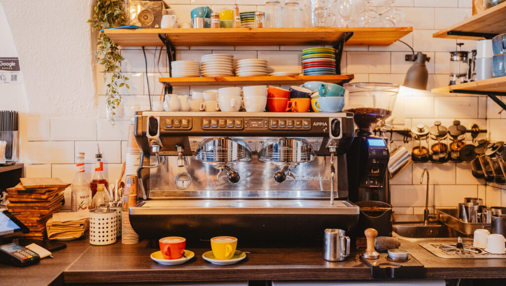 Espresso kávovar Nuova Simonelli Appia s farebnými šálkami na pulte kaviarne.